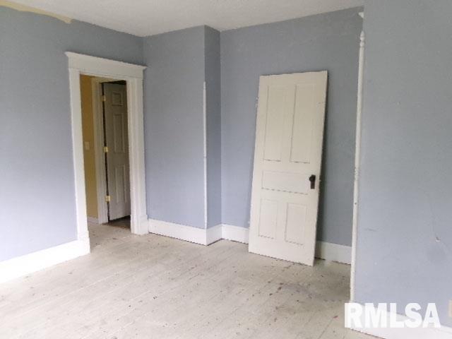 896 E Chestnut St, Canton, IL 61520 - empty room featuring baseboards and wood finished floors