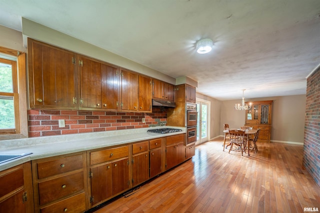 23907 Veterans Rd, Morton, IL 61550 - kitchen featuring brown cabinets, under cabinet range hood, light countertops, and appliances with stainless steel finishes