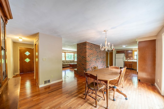 23907 Veterans Rd, Morton, IL 61550 - dining area featuring a chandelier, light wood-style flooring, and baseboards