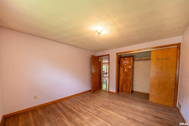 23907 Veterans Rd, Morton, IL 61550 - unfurnished bedroom featuring wood finished floors, baseboards, and a closet