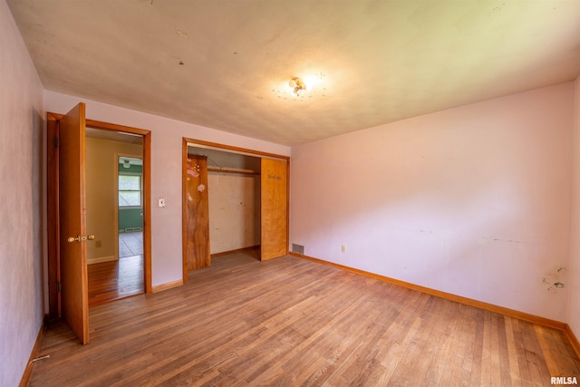 23907 Veterans Rd, Morton, IL 61550 - unfurnished bedroom with wood finished floors, baseboards, and a closet