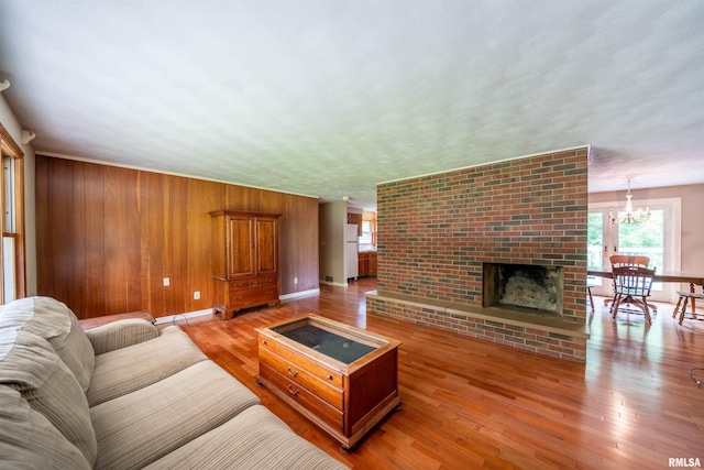 23907 Veterans Rd, Morton, IL 61550 - living room featuring healthy amount of natural light, a chandelier, wood finished floors, baseboards, and wooden walls