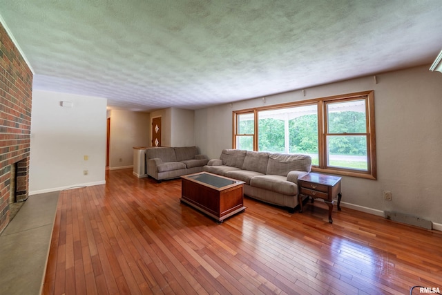 23907 Veterans Rd, Morton, IL 61550 - living room featuring wood-type flooring, baseboards, a textured ceiling, and a fireplace