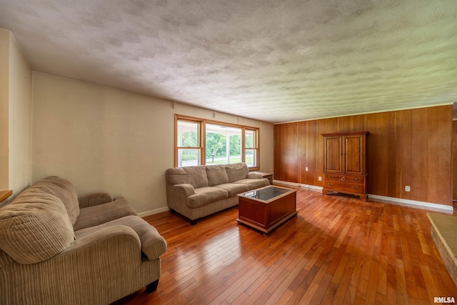 23907 Veterans Rd, Morton, IL 61550 - living room featuring baseboards, light wood-type flooring, a textured ceiling, and wood walls