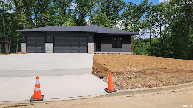 124 Rosemary Ln, Germantown Hills, IL 61548 - view of front facade with board and batten siding, driveway, a garage, and stone siding