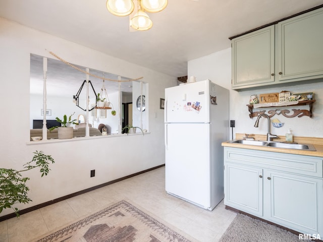 1402 Lincoln Rd, Marquette Heights, IL 61554 - kitchen featuring freestanding refrigerator, a sink, light countertops, a chandelier, and light tile patterned flooring