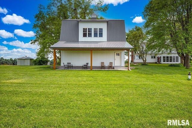 701 E Pearl St, Tremont, IL 61568 - back of house featuring a yard, a patio, metal roof, and a chimney
