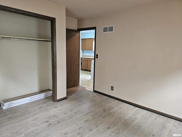 723 E Maywood Ave, Peoria, IL 61603 - unfurnished bedroom with light wood-style floors, a closet, and baseboards