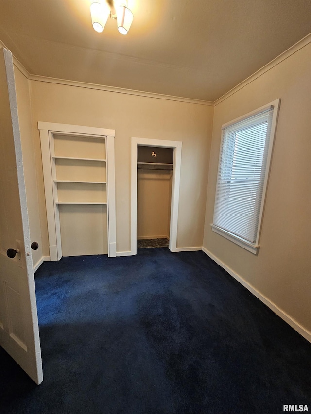 723 E Maywood Ave, Peoria, IL 61603 - unfurnished bedroom featuring crown molding, dark colored carpet, baseboards, and two closets