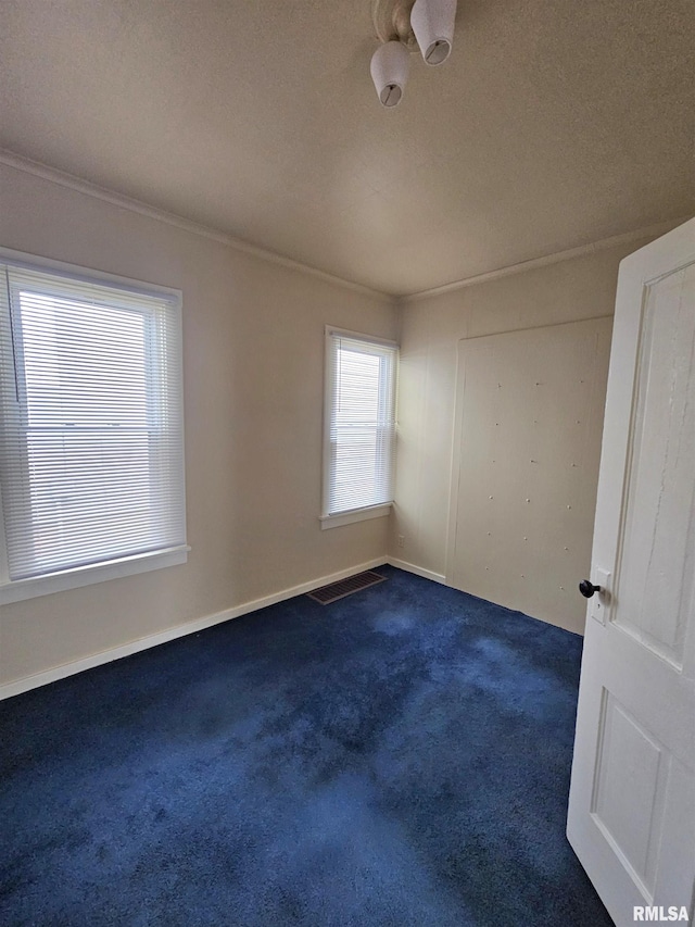 723 E Maywood Ave, Peoria, IL 61603 - spare room with crown molding, dark carpet, a textured ceiling, and baseboards