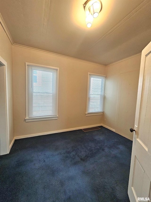 723 E Maywood Ave, Peoria, IL 61603 - spare room featuring dark carpet, healthy amount of natural light, crown molding, and baseboards
