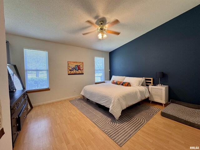 1041 Hawthorn Rdg, Macomb, IL 61455 - bedroom with multiple windows, wood finished floors, baseboards, ceiling fan, and a textured ceiling