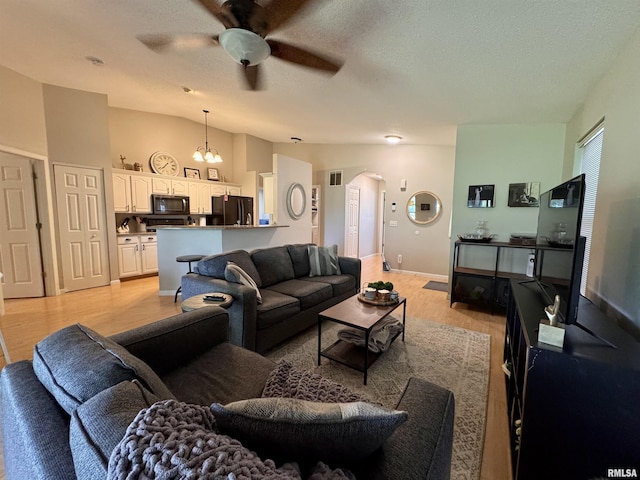 1041 Hawthorn Rdg, Macomb, IL 61455 - living room with arched walkways, ceiling fan, light wood finished floors, vaulted ceiling, and baseboards