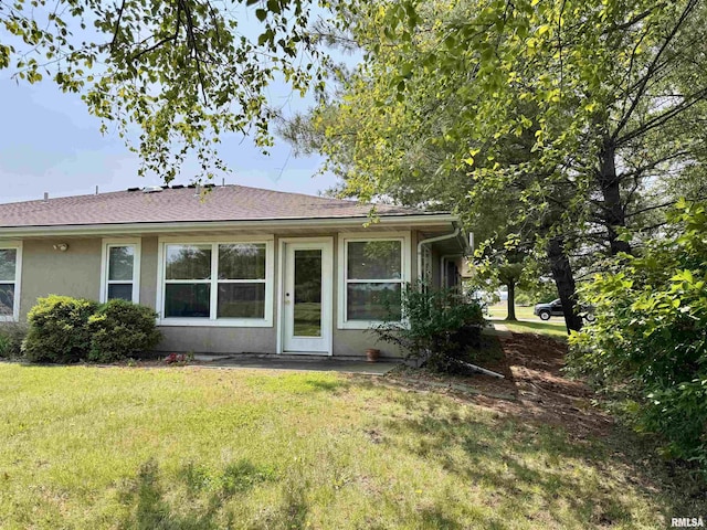 1041 Hawthorn Rdg, Macomb, IL 61455 - back of property featuring stucco siding, a yard, and roof with shingles