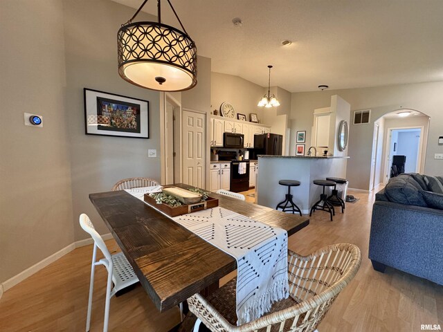 1041 Hawthorn Rdg, Macomb, IL 61455 - dining space featuring arched walkways, light wood finished floors, and baseboards