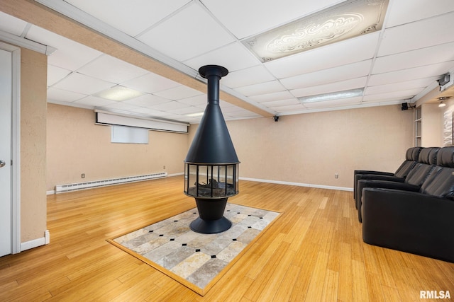 4517 W Hetherwood Dr, Peoria, IL 61615 - living room featuring baseboard heating, a drop ceiling, baseboards, and wood finished floors