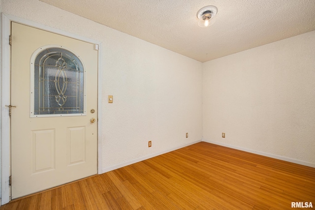 4517 W Hetherwood Dr, Peoria, IL 61615 - empty room with light wood-style flooring, baseboards, and a textured ceiling