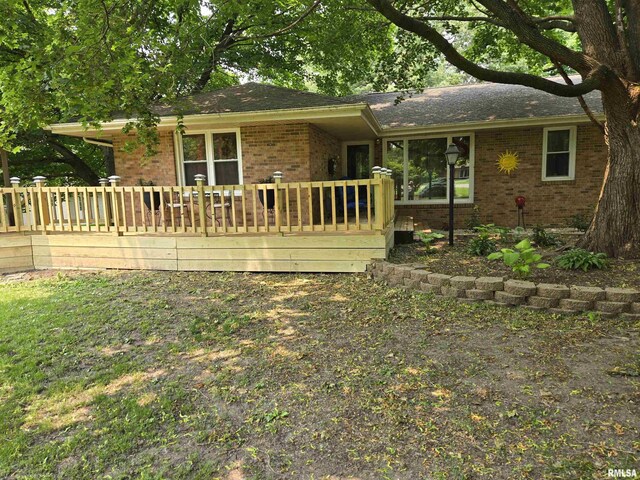 16324 E Cherokee Rd, Cuba, IL 61427 - rear view of house featuring brick siding, a wooden deck, and roof with shingles