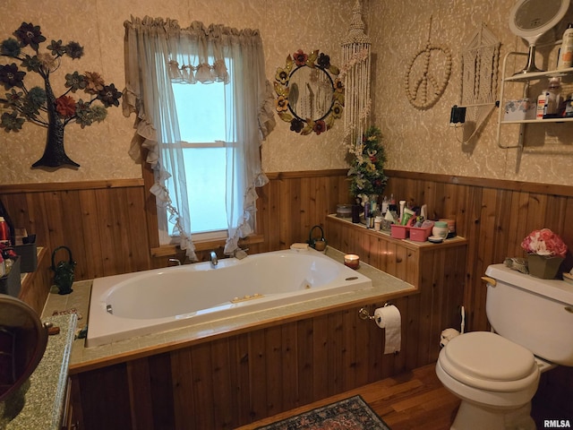16324 E Cherokee Rd, Cuba, IL 61427 - bathroom featuring a wainscoted wall, a garden tub, toilet, wood finished floors, and wallpapered walls