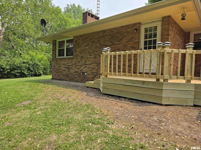 16324 E Cherokee Rd, Cuba, IL 61427 - view of home's exterior featuring brick siding, a deck, a chimney, and a yard