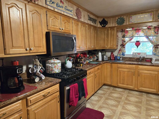 16324 E Cherokee Rd, Cuba, IL 61427 - kitchen with appliances with stainless steel finishes, a sink, dark stone countertops, and brown cabinets
