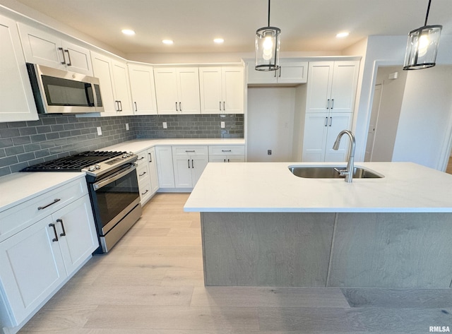4014 W Fiona Way, Dunlap, IL 61525 - kitchen with appliances with stainless steel finishes, light wood-type flooring, white cabinetry, tasteful backsplash, and pendant lighting