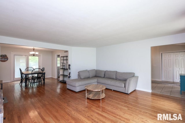 5232 N Merrimac Ave, Peoria, IL 61614 - living area with a chandelier, light wood-type flooring, and baseboards