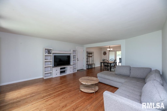 5232 N Merrimac Ave, Peoria, IL 61614 - living area with a chandelier, light wood-style flooring, and baseboards