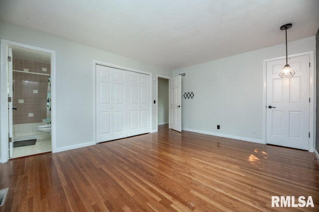 5232 N Merrimac Ave, Peoria, IL 61614 - unfurnished bedroom with wood finished floors, baseboards, ensuite bath, and a closet