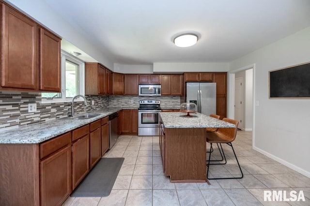 5232 N Merrimac Ave, Peoria, IL 61614 - kitchen featuring stainless steel appliances, backsplash, a breakfast bar, a sink, and light tile patterned floors