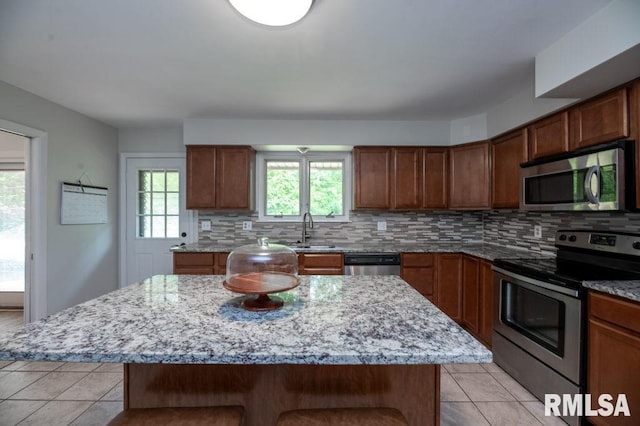 5232 N Merrimac Ave, Peoria, IL 61614 - kitchen with stainless steel appliances, light tile patterned floors, a sink, and decorative backsplash