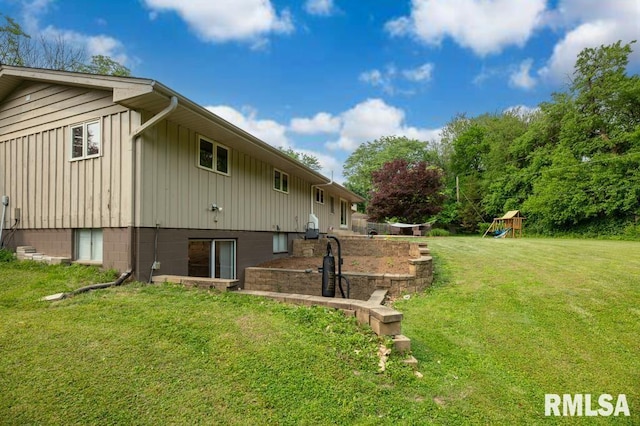 5232 N Merrimac Ave, Peoria, IL 61614 - view of side of property with board and batten siding, a yard, and a playground