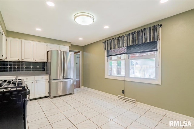 303 W 3rd Ave, Deer Creek, IL 61733 - kitchen featuring freestanding refrigerator, gas range, decorative backsplash, white cabinets, and recessed lighting