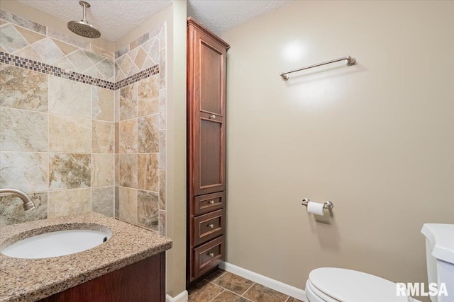 303 W 3rd Ave, Deer Creek, IL 61733 - bathroom with toilet, a textured ceiling, a tile shower, vanity, and tile patterned floors