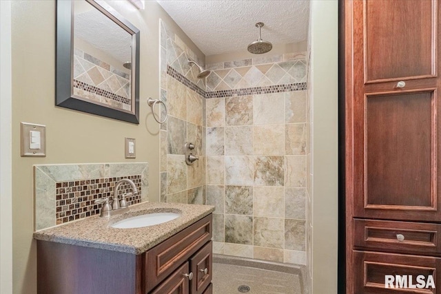 303 W 3rd Ave, Deer Creek, IL 61733 - bathroom featuring tiled shower, vanity, a textured ceiling, and tasteful backsplash