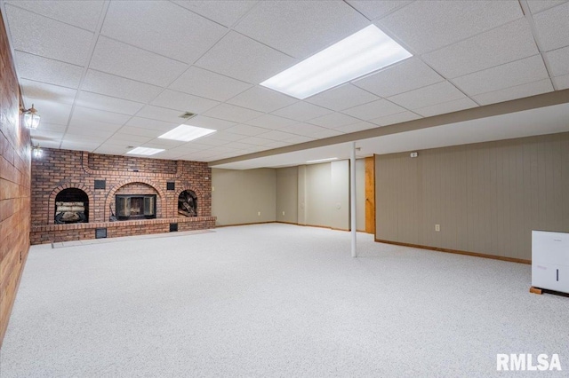 303 W 3rd Ave, Deer Creek, IL 61733 - finished below grade area featuring a brick fireplace, carpet floors, a drop ceiling, baseboards, and wood walls