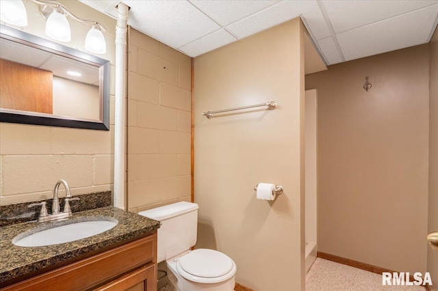 303 W 3rd Ave, Deer Creek, IL 61733 - full bathroom with toilet, vanity, a drop ceiling, concrete block wall, and a shower