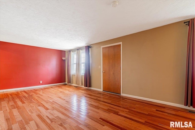 303 W 3rd Ave, Deer Creek, IL 61733 - spare room with light wood-style floors, baseboards, a textured ceiling, and a smoke detector