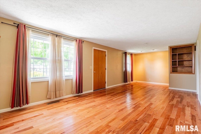 303 W 3rd Ave, Deer Creek, IL 61733 - spare room with a textured ceiling, light wood finished floors, and baseboards