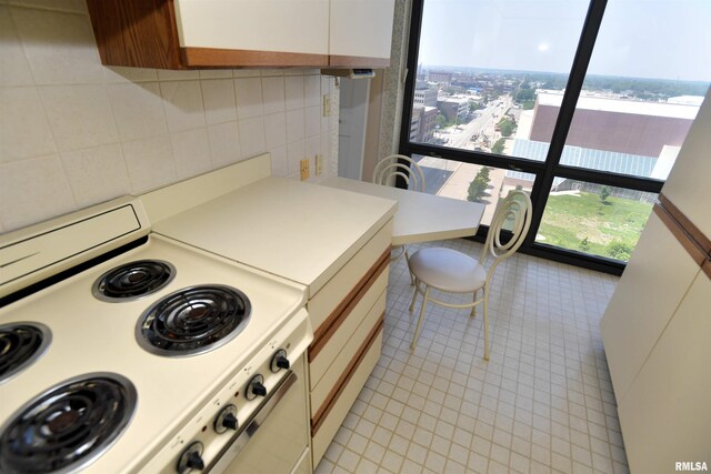 123 SW Jefferson Ave Unit E14A, Peoria, IL 61602 - kitchen with stove, light tile patterned floors, light countertops, and white cabinets