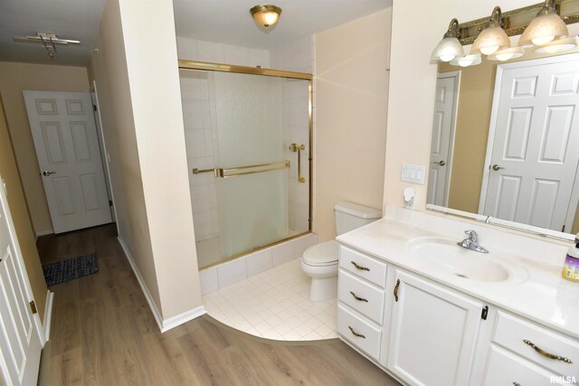 123 SW Jefferson Ave Unit E14A, Peoria, IL 61602 - bathroom featuring vanity, toilet, tiled shower, and wood finished floors