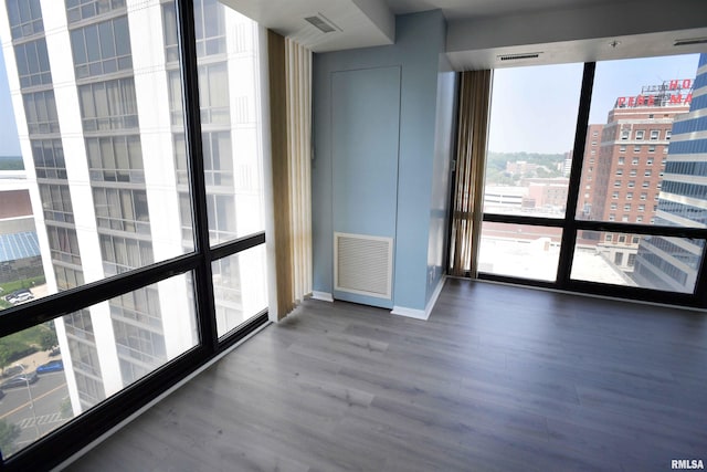 123 SW Jefferson Ave Unit E14A, Peoria, IL 61602 - unfurnished room with wood finished floors, a city view, and baseboards
