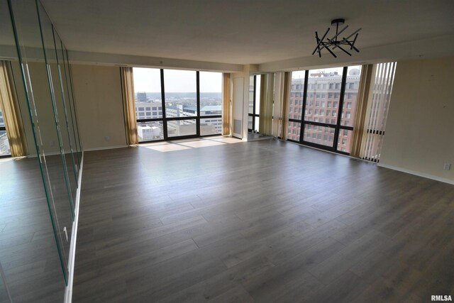 123 SW Jefferson Ave Unit E14A, Peoria, IL 61602 - spare room with a city view, dark wood-type flooring, baseboards, and expansive windows