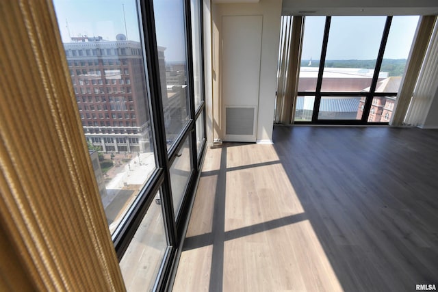 123 SW Jefferson Ave Unit E14A, Peoria, IL 61602 - empty room featuring wood finished floors, floor to ceiling windows, and a view of city