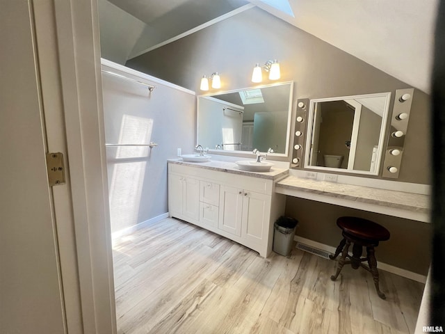283 Old Germantown Rd, East Peoria, IL 61611 - bathroom with a skylight, wood finished floors, toilet, lofted ceiling, and double vanity