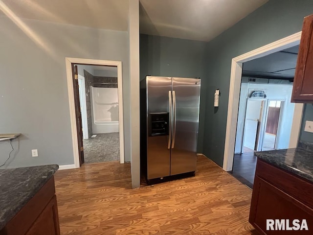 836 S Johnson St, Macomb, IL 61455 - kitchen featuring stainless steel refrigerator with ice dispenser, light wood finished floors, and dark stone countertops