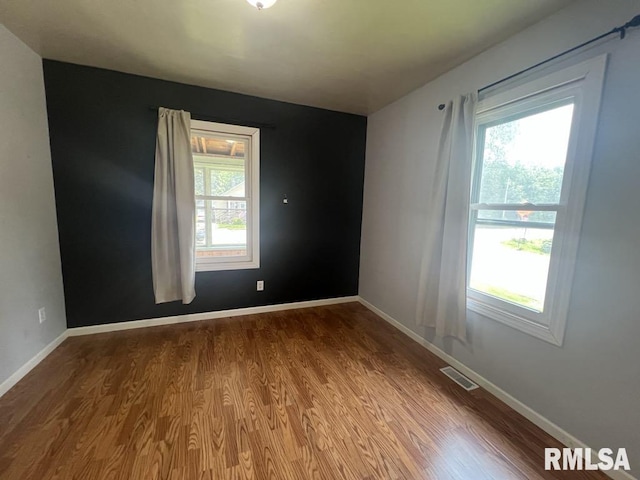 836 S Johnson St, Macomb, IL 61455 - unfurnished room with healthy amount of natural light, wood finished floors, and baseboards