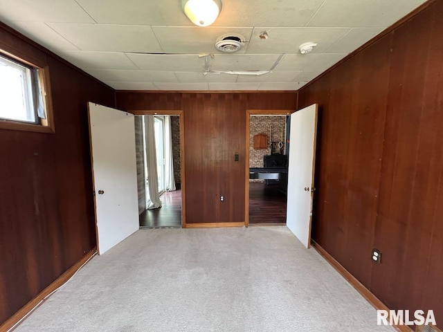 836 S Johnson St, Macomb, IL 61455 - unfurnished bedroom with wood walls and light carpet
