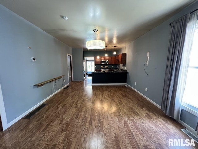 836 S Johnson St, Macomb, IL 61455 - unfurnished living room with dark wood-style flooring and baseboards