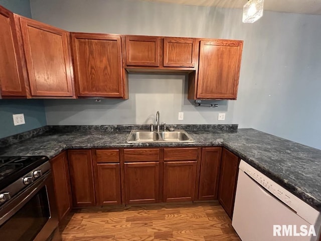 836 S Johnson St, Macomb, IL 61455 - kitchen featuring dishwasher, a sink, dark countertops, light wood-style flooring, and stainless steel range with gas stovetop
